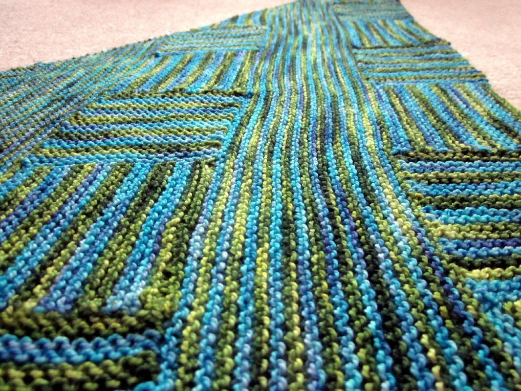 Log Cabin Shawl knitting pattern by Cassie Castillo.  Worked in striped modular sections.  Great stash buster!